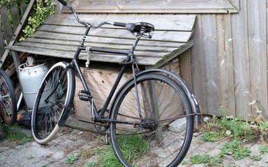 altes Fahrrad vor einer verwitterten Holzwand - 292529973