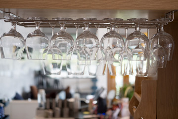 Wine glasses stacked hanging above bar
