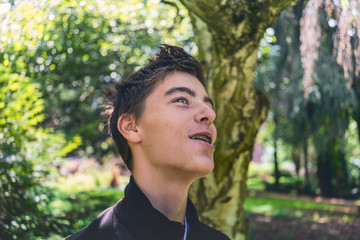laughing young man with tooth brace in a park