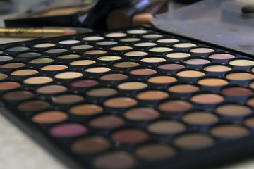 Close-up eyeshadow cosmetic palette with blurred foreground and background.