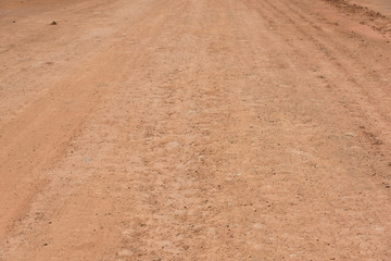 Naklejka premium Red mud dry soil road pavement low angle view background texture