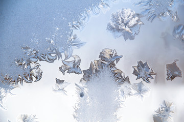 Frosty patterns on a winter window in cold colors.