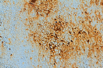 rusty metal wall with cracked blue paint, rust through the paint, close-up