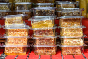 Bee honeycombs in individual plastic boxes available for sale at a street food market