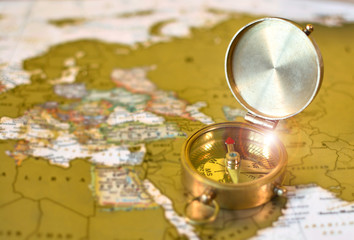Vintage bronze compass on a world map