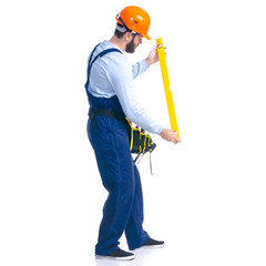 Man worker builder with helmet and tool belt, building level on white background isolation