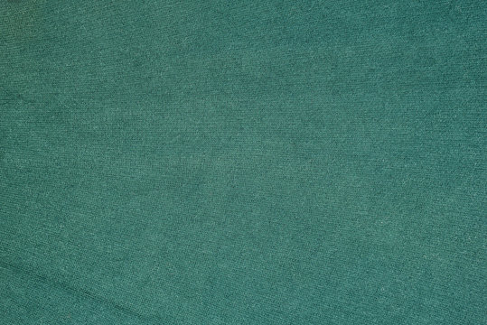 Green woolen texture fabric. Solid seamless background.