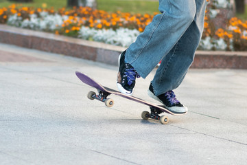 Men's legs, on a skateboard, with tricks.
