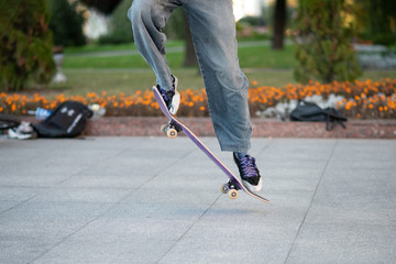 Men's legs, on a skateboard, with tricks.