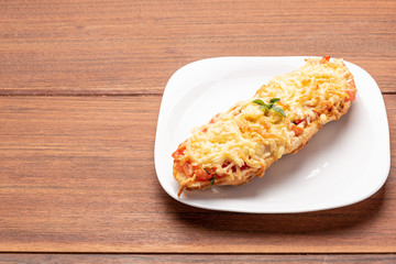 Bruschetta with tomatoes, mozzarella cheese and basil on a wooden background. Traditional italian appetizer or snack, antipasto. Isolated