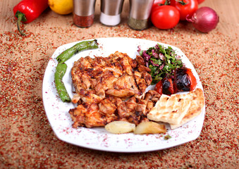 Grilled Chicken Serving on White Plate with Fresh Pepper and Salad with Fresh Vegetables on Spicy Wooden Table