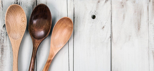 Wooden spoons on rustic wood - for food & culinary concepts - cooking and kitchen menu background / panorama / banner with design space.