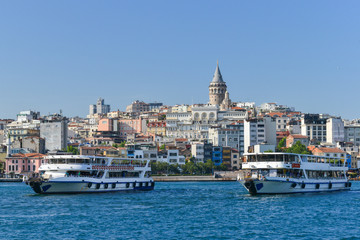 Istanbul cityscape including historical Galata Tower, Bosphorus,  passenger boats, and bridge