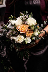 Woman florist with wedding bouquet of roses.