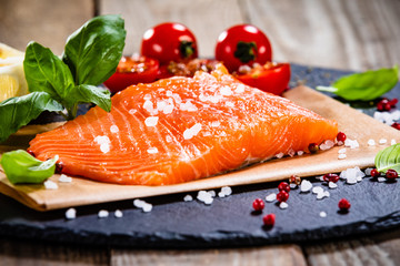 Fresh raw salmon fillets on black stone plate