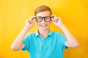 Kid at eye sight test. Stylish child holding glasses and looking at camera. Vision, eyesight...