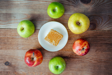 Honeycombs with honey and slices of ripe apples on wooden table.