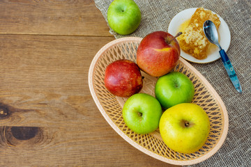 Honeycombs with honey and slices of ripe apples on wooden table.