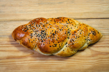 Challah with sesame seeds on wooden background