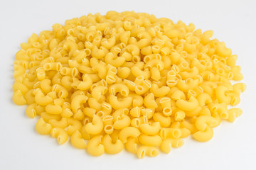 Group of dried corneti rigati Italian pasta ready to be cooked, isolated on a white table, side view