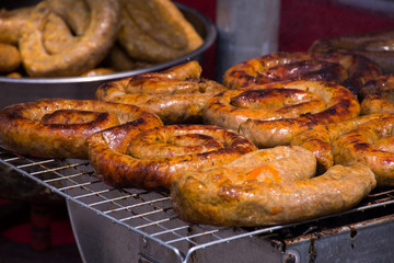Northern Thai spicy sausage (Sai Aua) grill on grates in street food market. Selective focus.