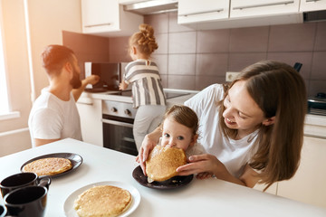 little girl her parents enjoying eating yummy pancakes. close up photo. happiness, weekend,...