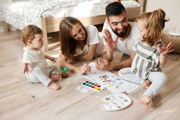 positive daddy and his daughet giving high five to each other enjoying painting process, happiness....