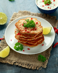 Corn fritters, pancake with dip white sauce, lime and chilli on white plate