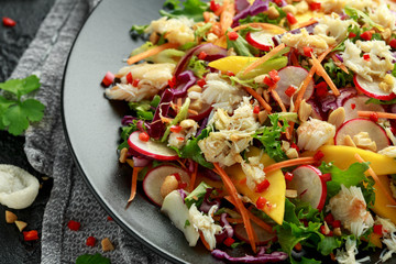 Crab salad with vegetables, radish, carrots, mango, pine nuts and prawn crackers