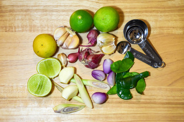 Food ingredient herb. lime, lemon grass, garlic, shallots and kaffir lime leaf on wooden background.