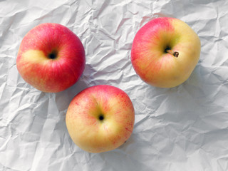 Red and yellow apples on white wrapping paper