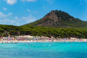 view on the beach of Cala Agulla Majorca Spain with many tourists