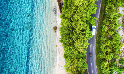 Aerial view on road in the forest. Highway throu the forest and sea coast. View from a drone....
