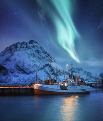 Aurora Borealis, Lofoten islands, Norway. Nothen light, mountains and boat. Winter landscape at the...