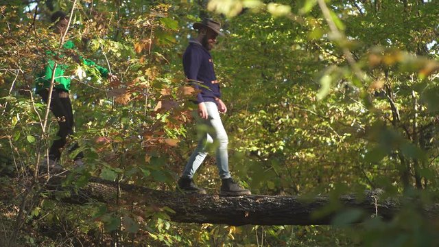 Happy couple climbing and having fun in forest. Outdoor Autumn atmospheric moments and dream. Active people. Hello Autumn. Hike concept. Couple hiking in the park.