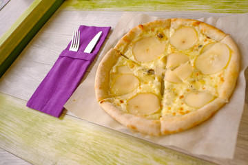 Delicious pizza with Round Pear Slices, Roquefort Blue Cheese served at Italian Restaurant with Plate. Traditional Food