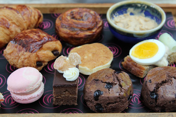 Luxury afternoon tea with dessert on wooden plate.