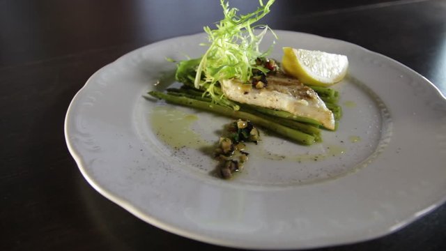 Grilled zander fillet with asparagus and lemon.White plate