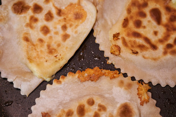 Frying chebureks in oil on a frying pan