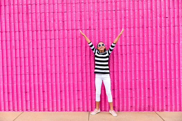 Cute caucasian girl celebrating her 13th birthday teenager standing in front of a hot pink wall...