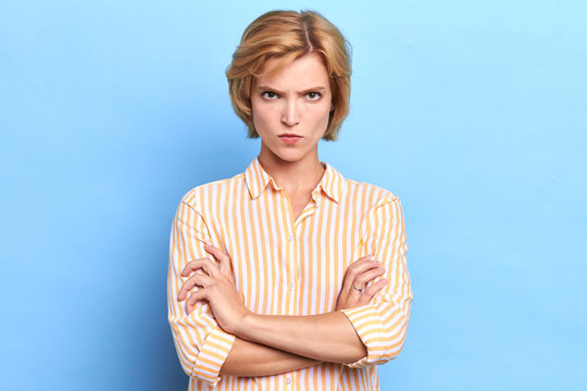 Angry unhappy sad woman looking at camera with sceptical and displeased expression, arms crossed. Portrait of beautiful female boss disappointed or angry with her office workers