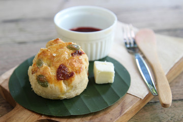 Delicious homemade muffin with butter on banana leaf on wooden tray.