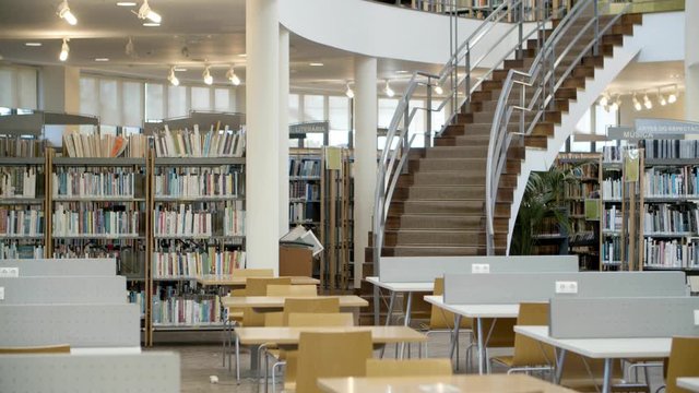 Interior of library with books on shelves and stairs. Public library interior. Modern library concept