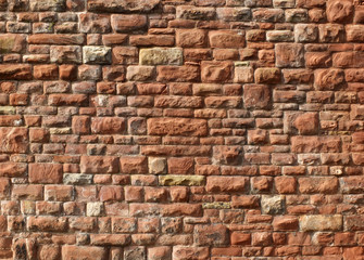 large red old sandstone wall with rough textured surface