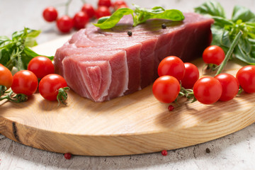 Wild Norwegian blue fin tuna steak with spices and vegetables on the cut board. Organic and healthy food concept.