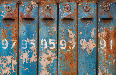 Row of old blue mailboxes with numbers