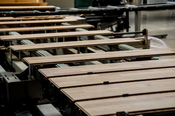 Production line of the wooden floor factory. CNC automatic woodworking machine.
