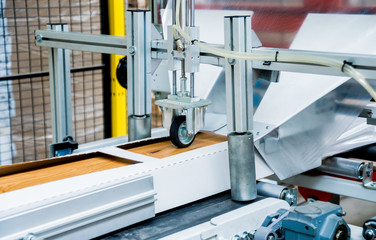 Production line of the wooden floor factory. CNC automatic woodworking machine.