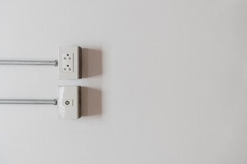 Wall outlet for power cord cable plugged on white wall with copy space.