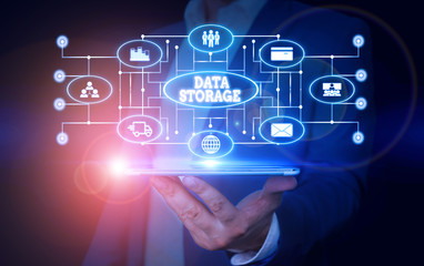 Conceptual hand writing showing Data Storage. Concept meaning the act of archiving data in electromagnetic or other forms Male wear formal suit presenting presentation smart device